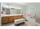 Well-lit bathroom with double sinks, framed mirror, soaking tub, glass shower, and vanity at 16158 W Copper Point Ln, Surprise, AZ 85374