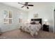 Bedroom with neutral carpet, ceiling fan, and plantation shutters filtering sunlight at 16158 W Copper Point Ln, Surprise, AZ 85374
