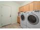 Bright laundry room features tile floor, cabinets, washer, and dryer at 16158 W Copper Point Ln, Surprise, AZ 85374