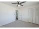 Bright bedroom with carpet, ceiling fan, closet, and door to an attached bathroom at 1708 W Estrella Dr, Chandler, AZ 85224