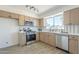 Modern kitchen with stainless steel appliances, light wood cabinets, and bright countertops at 1708 W Estrella Dr, Chandler, AZ 85224