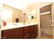 Bathroom featuring dual sinks, wood cabinets, and a separate toilet area at 17516 W Pershing St, Surprise, AZ 85388