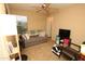 Bedroom features comfortable sitting area, a ceiling fan, and natural light at 17516 W Pershing St, Surprise, AZ 85388