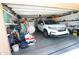 A garage packed with boxes and assorted clutter that features a car, fan, and cleaning supplies at 17516 W Pershing St, Surprise, AZ 85388