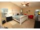 Well-lit main bedroom featuring a ceiling fan, neutral carpet, a large bed and dresser furniture at 17516 W Pershing St, Surprise, AZ 85388