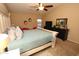 Spacious main bedroom featuring a ceiling fan, neutral carpet, a large bed and dresser furniture at 17516 W Pershing St, Surprise, AZ 85388