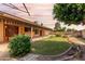 Manicured backyard featuring lush lawn, patio, and mature tree, providing a serene outdoor space at 18814 N 33Rd Ave, Phoenix, AZ 85027