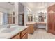 Bright bathroom with wood cabinets, large mirror, and tile floors at 18814 N 33Rd Ave, Phoenix, AZ 85027