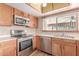 Cozy kitchen with stainless steel appliances, wood cabinetry and adjacent breakfast bar at 18814 N 33Rd Ave, Phoenix, AZ 85027