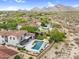 Aerial view of the home featuring a pool, patio, outdoor kitchen, and mountain views at 19829 N 97Th St, Scottsdale, AZ 85255