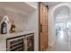Features a built-in wine fridge with stylish beverages, stone accents, and a unique sliding wooden door in an elegant design at 19829 N 97Th St, Scottsdale, AZ 85255