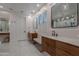 Modern bathroom featuring floating wood vanities, white marble countertops, and stylish lighting at 19829 N 97Th St, Scottsdale, AZ 85255