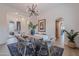 Open dining space with a stylish chandelier, modern furnishings, elegant artwork, and multiple arched entries for seamless flow at 19829 N 97Th St, Scottsdale, AZ 85255