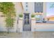 Inviting front entrance with metal gate and lush climbing greenery at 19829 N 97Th St, Scottsdale, AZ 85255