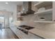 Modern kitchen features stainless steel hood, gas range, white cabinetry, open shelving, and stone backsplash for a sleek design at 19829 N 97Th St, Scottsdale, AZ 85255