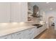 This kitchen showcases white cabinets, marble countertops, open shelving, and a stainless steel range hood at 19829 N 97Th St, Scottsdale, AZ 85255