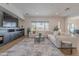 Bright living room features a large sectional sofa, decorative rug, and stylish built-in entertainment center at 19829 N 97Th St, Scottsdale, AZ 85255