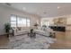 Open-concept living room showing seamless flow to kitchen and large sectional sofa with decorative rug at 19829 N 97Th St, Scottsdale, AZ 85255