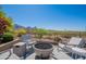 Relaxing outdoor patio with comfortable seating around a modern fire pit and scenic mountain views at 19829 N 97Th St, Scottsdale, AZ 85255