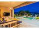 Inviting covered patio features a lounge area and overlooks a gorgeous pool with mountain views at 19829 N 97Th St, Scottsdale, AZ 85255