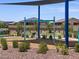 Community playground with swings is adjacent to attractive landscaping, walkways and neighborhood homes at 20795 N Roadrunner Ln, Maricopa, AZ 85138