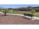 A community park shows a walking path, trees, and a bench with residential homes in the background at 20795 N Roadrunner Ln, Maricopa, AZ 85138