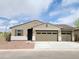 Charming single-story home featuring a tan stucco exterior, two-car garage, and well-maintained landscaping at 20795 N Roadrunner Ln, Maricopa, AZ 85138
