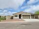 Charming single-story home featuring a tan stucco exterior, two-car garage, and low maintenance front yard at 20795 N Roadrunner Ln, Maricopa, AZ 85138