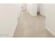 Tiled hallway with white walls and doors leading to various rooms at 20795 N Roadrunner Ln, Maricopa, AZ 85138