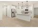 An open concept kitchen features stainless steel appliances and a kitchen island with pendant lighting overhead at 20795 N Roadrunner Ln, Maricopa, AZ 85138
