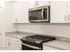 Close-up of kitchen with stainless steel microwave and cooktop with granite countertops at 20795 N Roadrunner Ln, Maricopa, AZ 85138