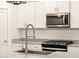 Close-up of kitchen with stainless steel microwave and modern fixtures over a granite countertop at 20795 N Roadrunner Ln, Maricopa, AZ 85138