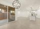 Open-concept living space with tile flooring, a modern chandelier, and sliding glass door to the patio at 20795 N Roadrunner Ln, Maricopa, AZ 85138