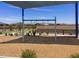 Community playground with a single-seat swing set, bordered by landscaping and residences at 20795 N Roadrunner Ln, Maricopa, AZ 85138