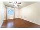 Bedroom with wood-look floors, a ceiling fan, neutral walls, and natural light from the window at 22755 W Yavapai St, Buckeye, AZ 85326