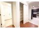 Hallway with storage closet, laminate and tile flooring, and access to the kitchen and front door at 22755 W Yavapai St, Buckeye, AZ 85326