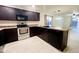 Modern kitchen featuring stainless steel appliances, dark cabinetry, and tile flooring at 22755 W Yavapai St, Buckeye, AZ 85326