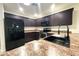 Well-equipped kitchen featuring dark cabinetry, stainless steel appliances, and modern countertops at 22755 W Yavapai St, Buckeye, AZ 85326