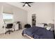 Cozy bedroom featuring a ceiling fan, a desk with a chair, and an open closet at 22962 N 182Nd Ln, Surprise, AZ 85387