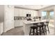 Bright kitchen features white cabinets, stainless steel appliances, quartz countertop and island with breakfast bar seating at 22962 N 182Nd Ln, Surprise, AZ 85387