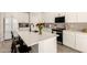 Bright kitchen features white cabinets, stainless steel appliances, quartz countertop and island with breakfast bar seating at 22962 N 182Nd Ln, Surprise, AZ 85387