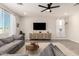 Light-filled living room with a modern ceiling fan, neutral furniture, stylish console, and large windows at 22962 N 182Nd Ln, Surprise, AZ 85387