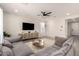 The airy living room features a modern ceiling fan, comfortable seating, media console, and a large area rug at 22962 N 182Nd Ln, Surprise, AZ 85387
