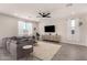 Bright living room features a ceiling fan, recessed lighting, plush sofa, and large windows with sheer curtains at 22962 N 182Nd Ln, Surprise, AZ 85387