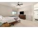 Relaxing main bedroom with neutral carpet, ceiling fan, TV on dresser, and ensuite bathroom at 22962 N 182Nd Ln, Surprise, AZ 85387