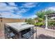 Outdoor kitchen and bar area featuring seating, stone countertops, and surrounding greenery at 29214 N 19Th Ln, Phoenix, AZ 85085