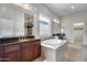 Bright primary bathroom featuring tile floors, a soaking tub, and and sinks at 29214 N 19Th Ln, Phoenix, AZ 85085