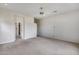 Large bedroom showcasing neutral carpet, ceiling fan, and an open doorway to an adjoining bathroom at 29214 N 19Th Ln, Phoenix, AZ 85085