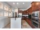 Modern kitchen with dark cabinets, stainless steel appliances, and breakfast bar at 29214 N 19Th Ln, Phoenix, AZ 85085