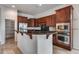 Well-equipped kitchen with dark wood cabinets, granite countertops, and stainless steel appliances at 29214 N 19Th Ln, Phoenix, AZ 85085